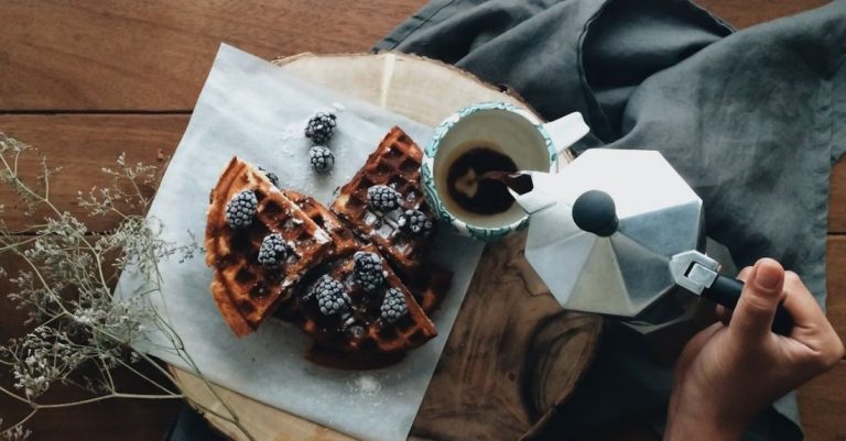 Energy Provider - From above of crop anonymous person holding pot and pouring coffee in mug near fresh waffles with berries