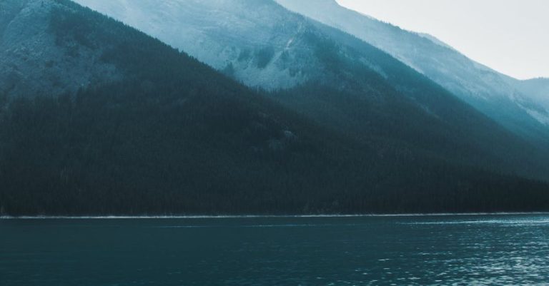 Travel Tips - Boat tip floating on rippling lake in mountainous terrain